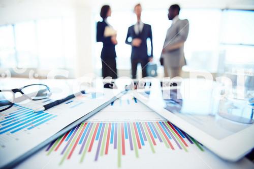 Business Documents And Touchpad With Charts On Desk